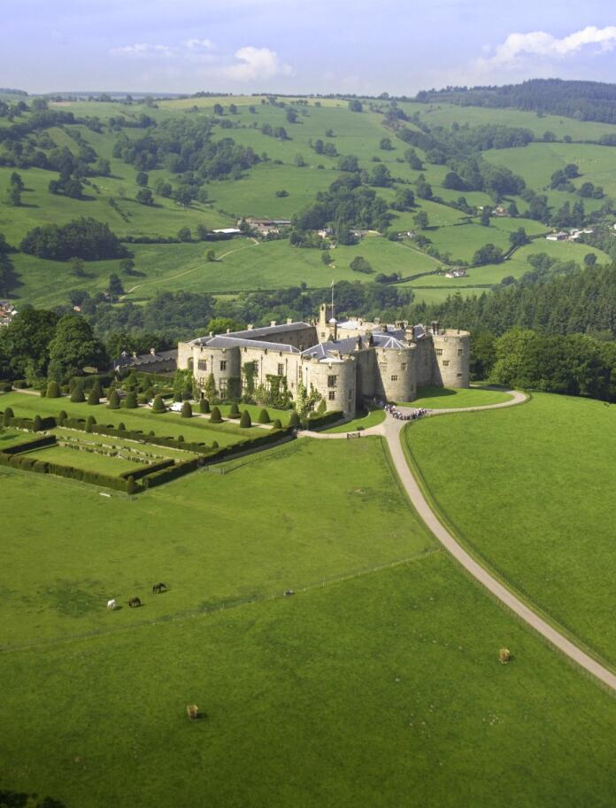 An aerial view of Chirk Castle and gardens with mountains in the background. 