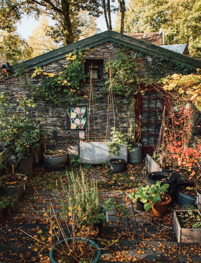 A stone hut with a vegetable garden outside.