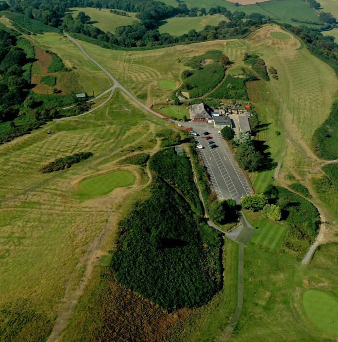 Aerial shot of a golf club and golf course surrounded by countryside.