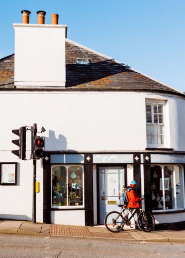 A man on a bike outside the exterior shot of Gate Gallery and Glassworks.