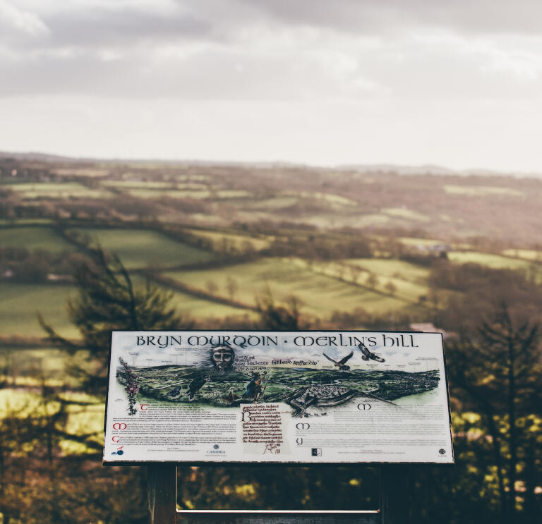 A viewpoint of Merlin's Hill with a sign detailing what you can see beyond.