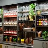 Shelves containing bottles of gin, glasses and shakers.